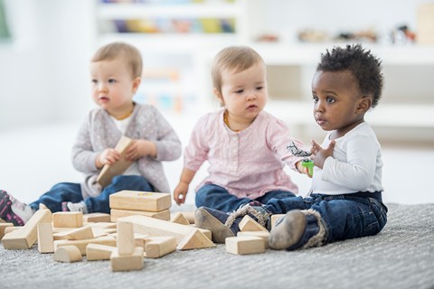 3 enfants jouant à un jeux de construction en bois